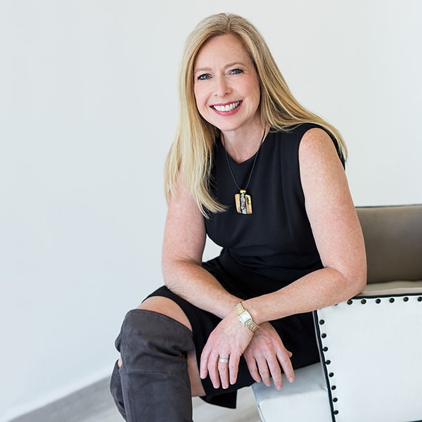 In the Press With Bridget Grimes, CFP® Headshot 3 With Gold Necklace Sitting on Chair