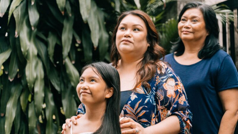 3 generations of women in a line in a tropical setting